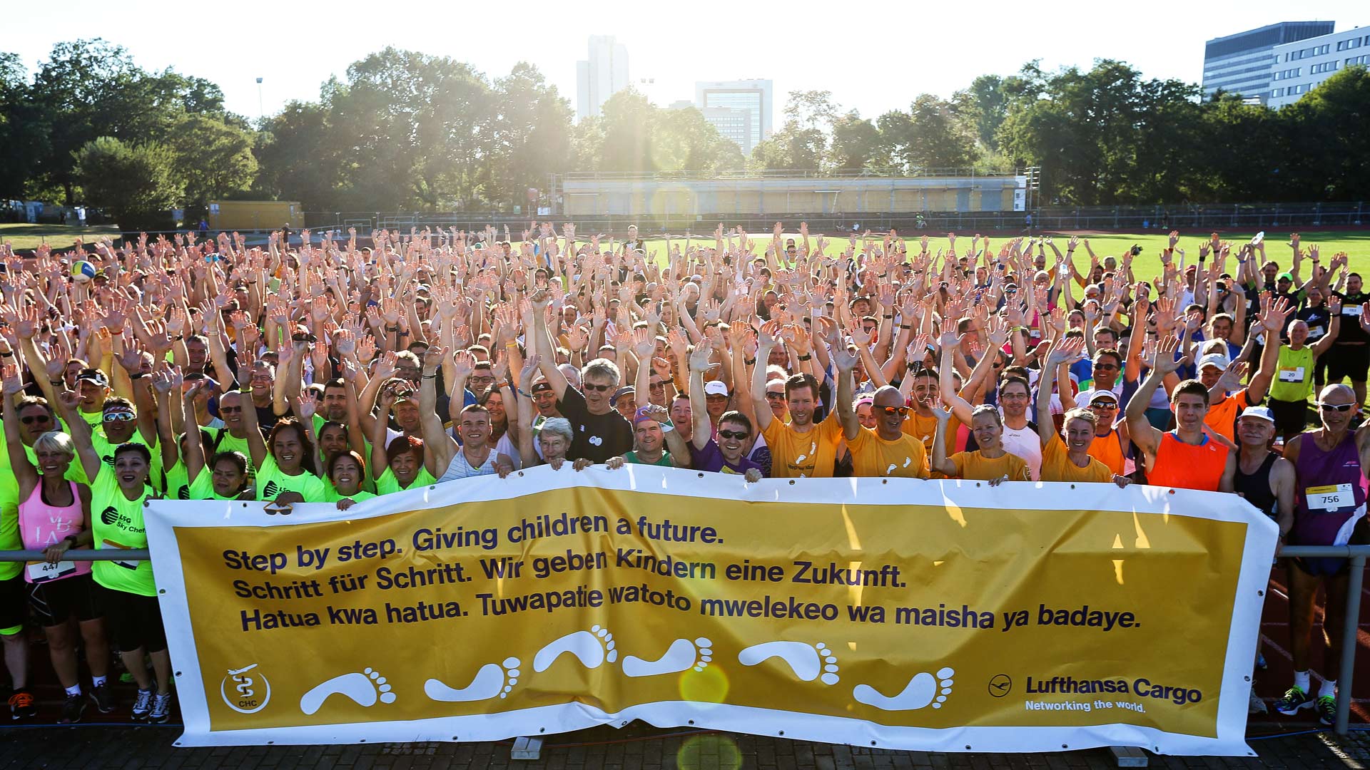 Gruppenfoto vom Bürostadtlauf vor untergehender Sonne mit Banner des Vereins
