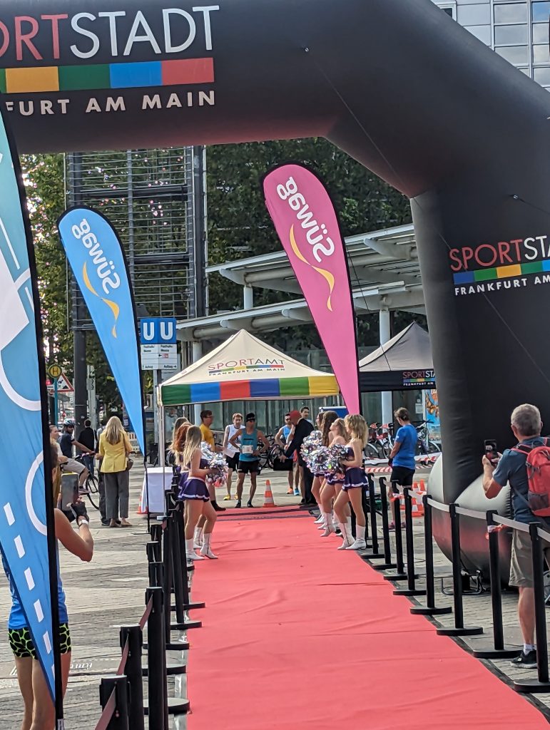 Aufnahme am Start zum SkyRun, zu sehen ist ein roter Teppich, an dessen Ende ein Pavillon mit einem Sportler im blauen Trikot. rechts und links davon Cheerleader.